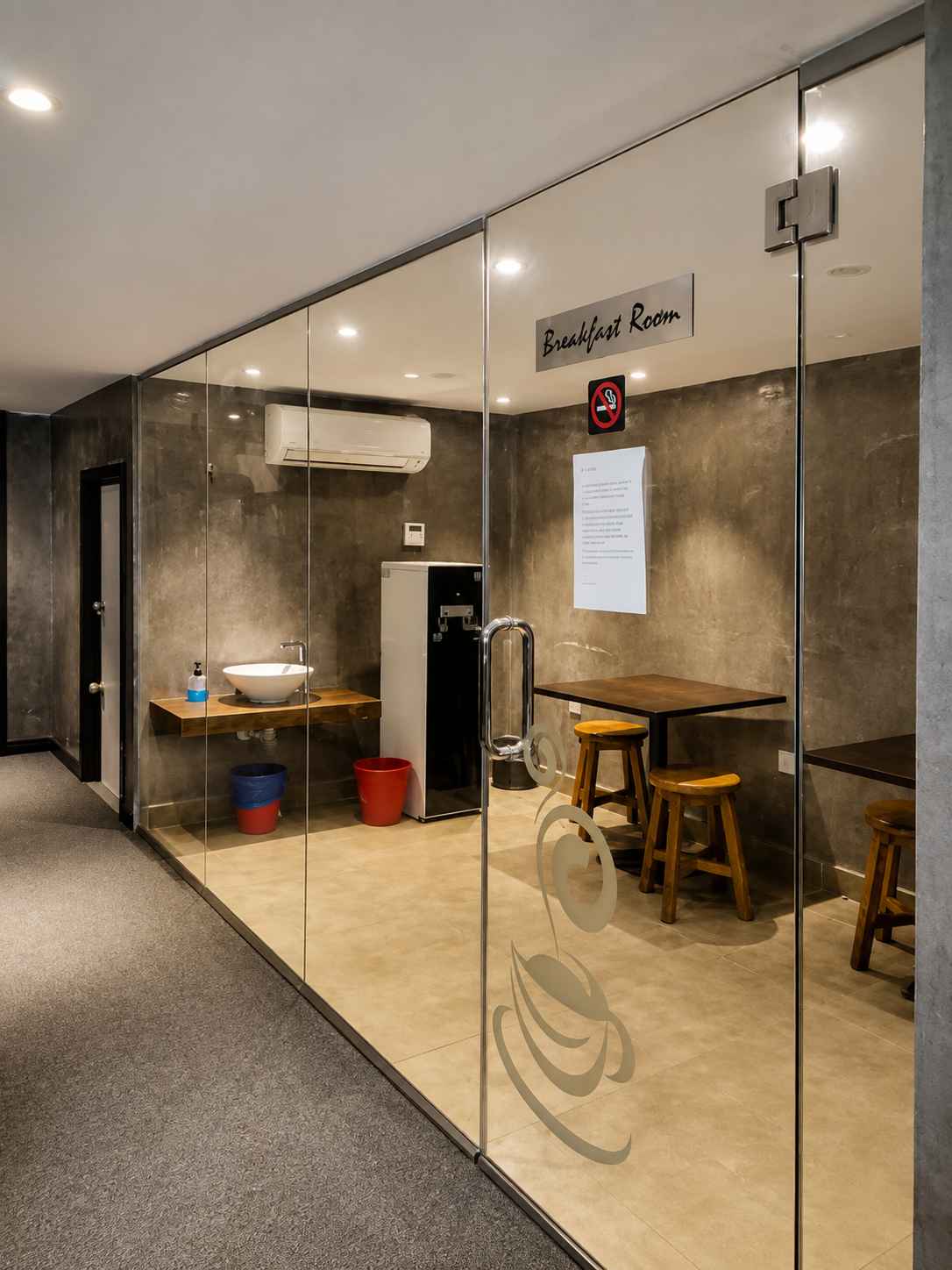 Hotel corridor leading past the glass-walled breakfast room